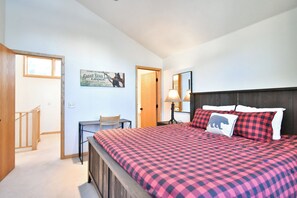 A bedroom with a checkered bedspread, a desk with a chair, a lamp, and a poster on the wall. - Royal Aspen Retreat Home: Lovely Setting, Spacious (Breckenridge)