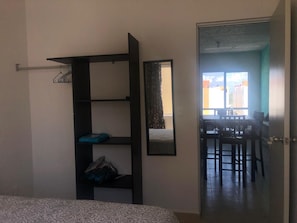 Cozy retreat with a bed, wardrobe, and dining area.
