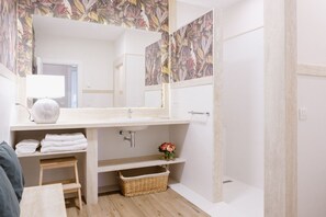 Regadera, secadora de cabello, toallas, papel de baño 