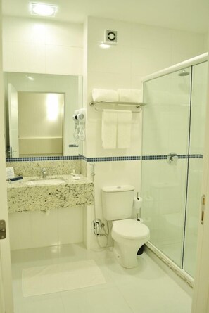 A bathroom with a sink, toilet, and glass shower enclosure.
