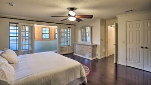 Un dormitorio con cama, cómoda y ventilador de techo.