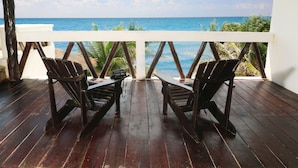A wooden deck with two chairs facing a view of the ocean. - Mi Casa Del Mar B4 - Unwind & rejuvenate in the natural beauty of the Caribbean (Akumal)