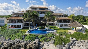 A resort with multiple buildings, a swimming pool, and palm trees. - Mi Casa Del Mar B4 - Unwind & rejuvenate in the natural beauty of the Caribbean (Akumal)