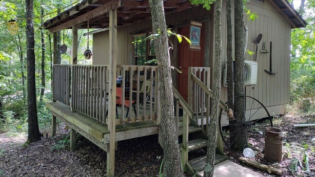 A rustic cabin with a wooden deck, a small porch, and a door labeled "WELCOME". - NEW!  Village of Hope - Cabin #5 (Ava)