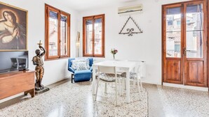 A room with a white table, blue sofa, wooden cabinet, and a statue. - GuestHost - Bright apartment, of about 80 sqm with period furniture, which can accommodate up to 4 people, located on the third floor (NO lift) of a typical Venetian building. The building boasts a very central position: it is a two-minute walk from Piaz (Venezia)