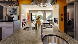 A modern kitchen with granite countertops, stainless steel appliances, and a central island with a sink.
