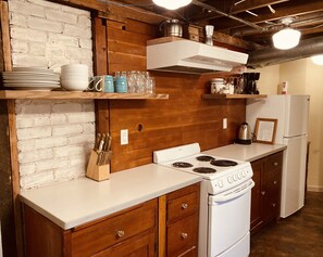 Eine Küche mit Holzschränken, einem weißen Herd und einem Kühlschrank.
