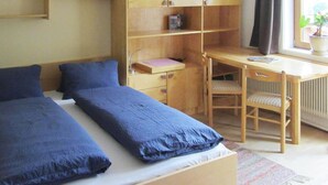 A bedroom with two beds, a desk, and a chair. - Chalet in Krimml near Waterfalls (Krimml)