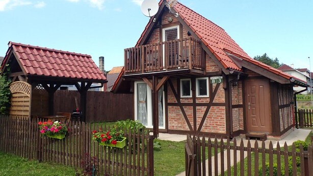 A traditional half-timbered house with a red-tiled roof, a balcony, and a wooden fence. - holiday home, Kolczewo (Kolczewo)
