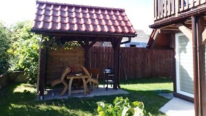 A wooden pergola with a tiled roof in a backyard. - holiday home, Kolczewo (Kolczewo)