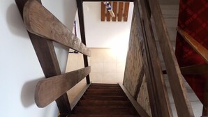 Eine Holztreppe mit Handlauf auf einer Seite und Wand auf der anderen.