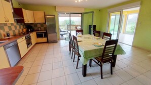 A kitchen with a dining area, a refrigerator, and a table set for four.