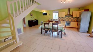 A spacious kitchen with a dining area, a staircase, and a modern design.