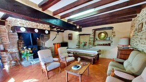 Un salon chaleureux avec une cheminée, des meubles en bois et un mur en pierre.