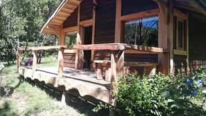 Une cabane en bois avec une véranda, une fenêtre et une porte.