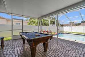 An indoor pool area with a pool table and a pool.