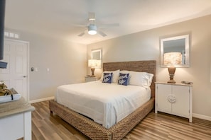 Une chambre à coucher avec un lit, un ventilateur de plafond, des lampes de chevet et une table de chevet.