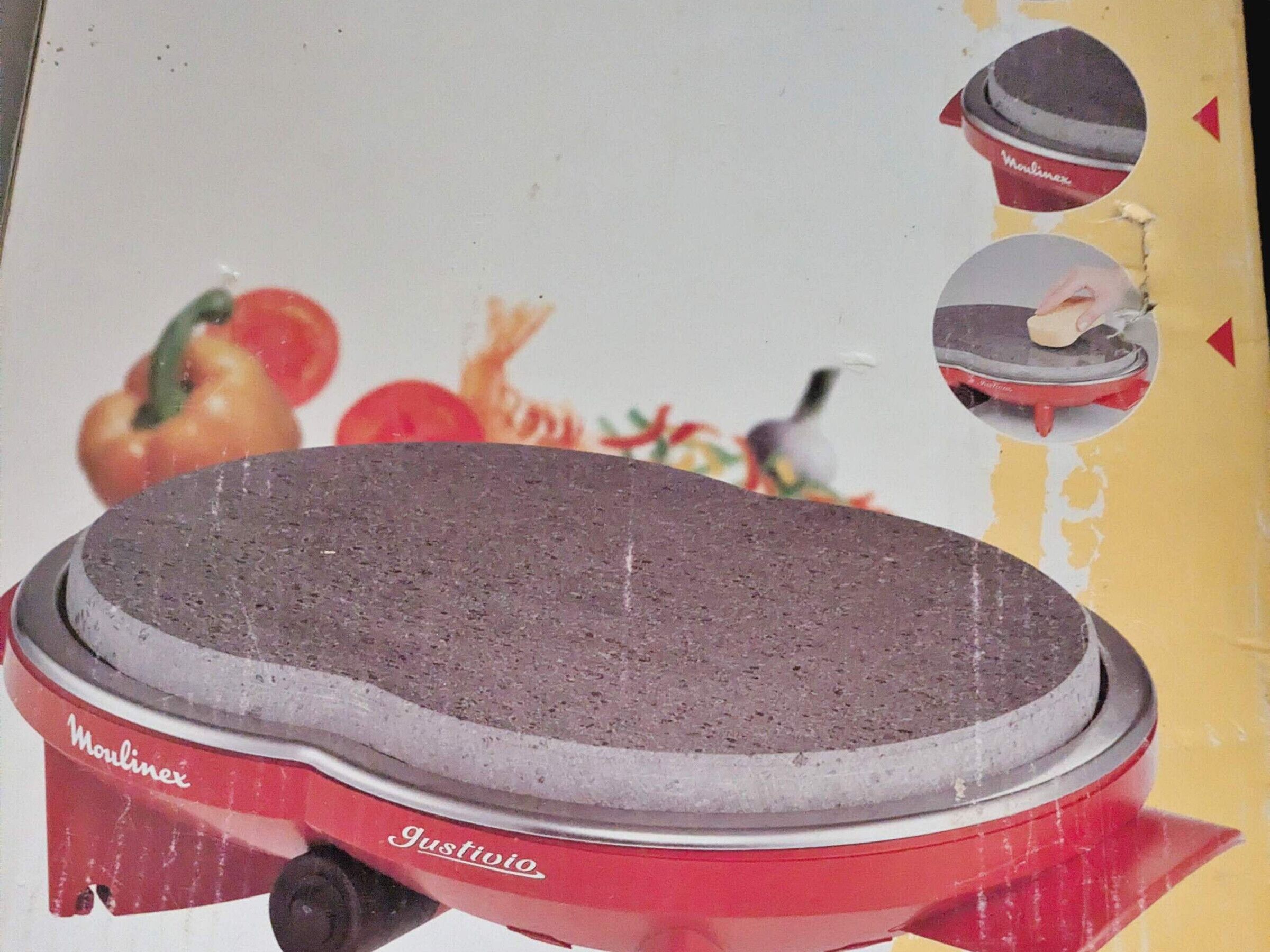 Un appareil de cuisine rouge et blanc, probablement un batteur ou un robot culinaire, sur lequel on peut voir les marques « Moulinex » et « Justio ».