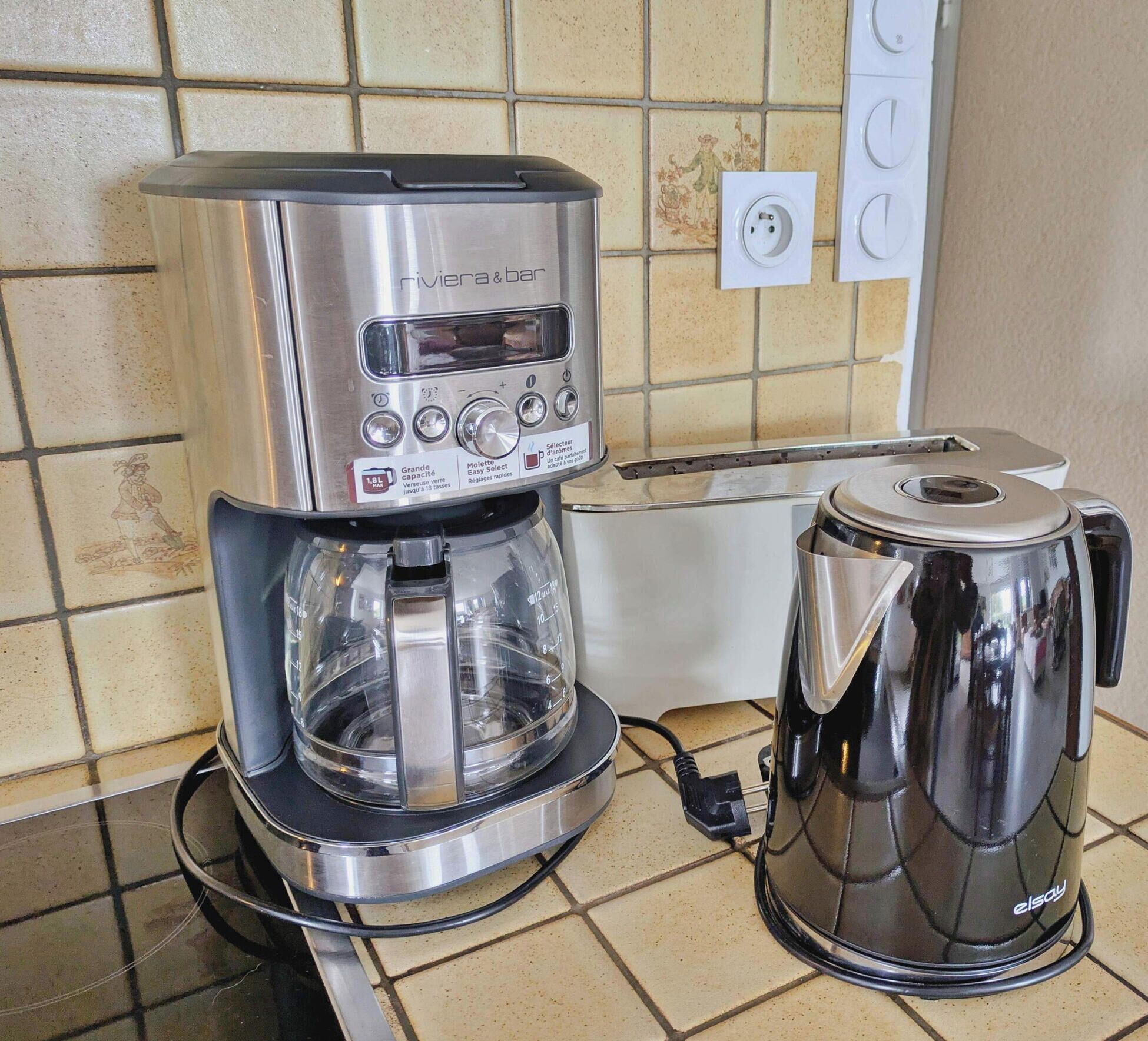 Keittiössä on kahvinkeitin ja vedenkeitin työtasolla.