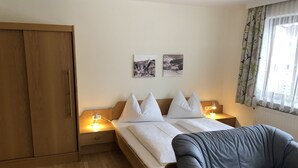 Ein Hotelzimmer mit einem Bett, Nachttischlampen, einem Kleiderschrank und einem Schlafsofa.