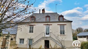 A two-story house with a central staircase, a chimney, and a small garden area. - Charming Countryside Retreat with Farm Experience and Nearby Forest (L'Huisserie)