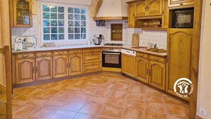 Una cocina con armarios de madera, una ventana, una estufa y un microondas.