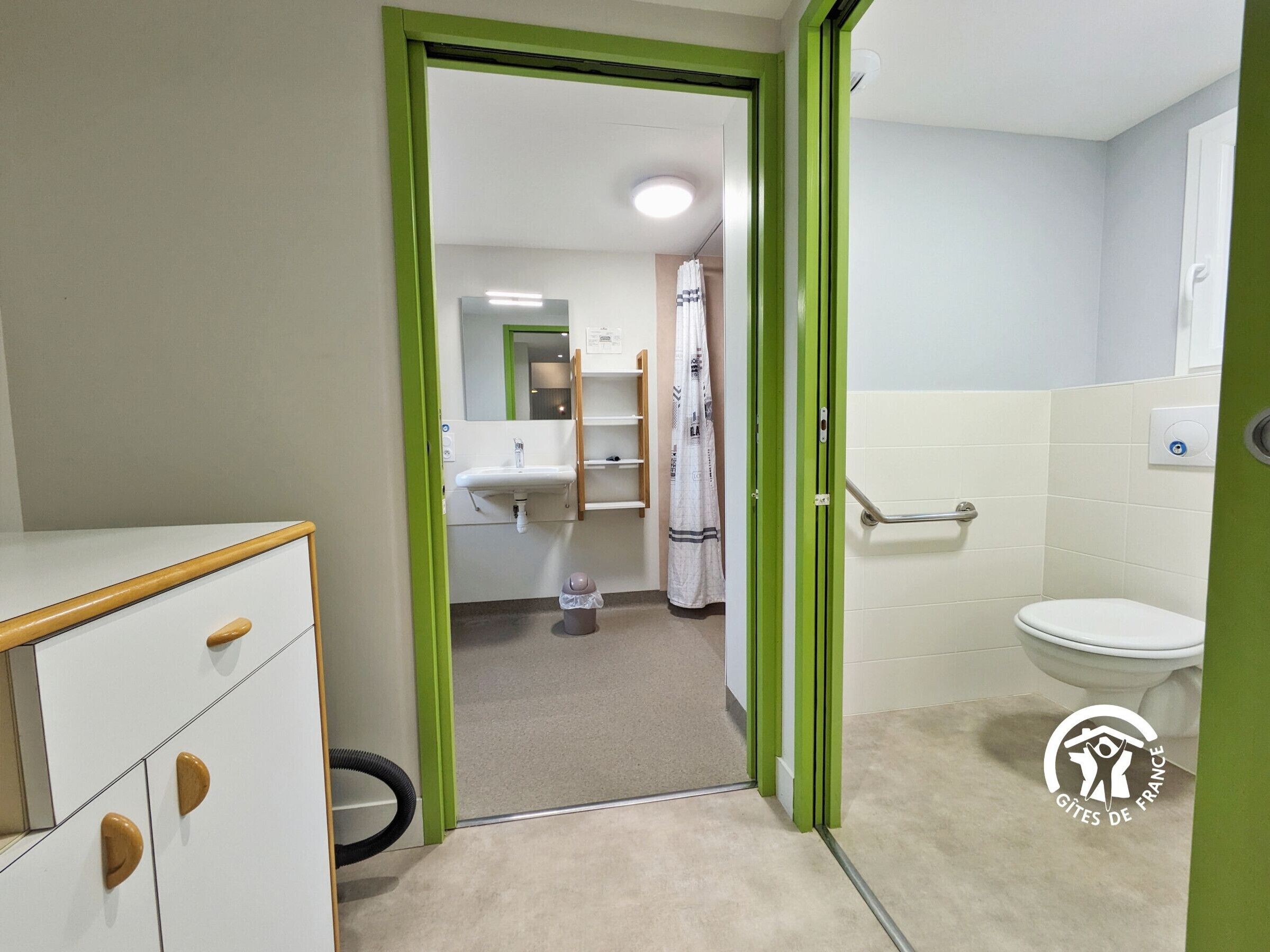 Une salle de bain comprenant des toilettes, un lavabo et un espace douche.