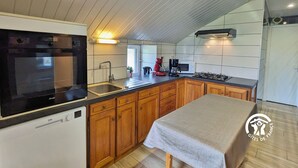 A modern kitchen with a built-in oven, microwave, and gas stove.