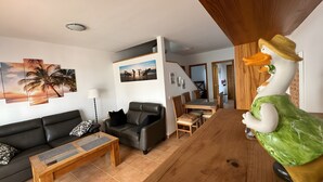 Ein Wohnzimmer mit einer Couch, einem Couchtisch und einem Holzessttisch.