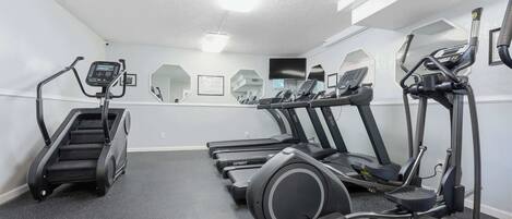 A gym with treadmills, an elliptical, and a stair climber.