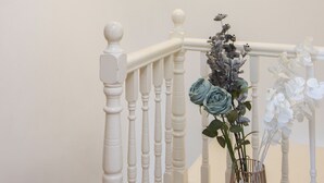 En trappa med vita trappspjälor och en vas med blommor på trappavsatsen.