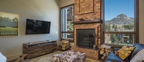 A living room with a fireplace, a television, and a sofa.