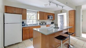 Una cocina moderna con armarios de madera, una isla central y un refrigerador.