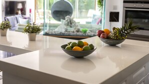 Una cocina con un bol de fruta, un acuario y vistas al exterior.