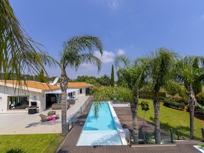 A modern house with a swimming pool, outdoor furniture, and palm trees. - Protaras Oscar Domain Villa A4 (Protaras)