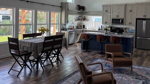 A spacious kitchen with high ceilings, large windows, and a ceiling fan.