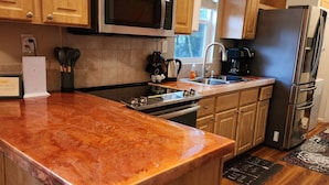Une cuisine avec des meubles en bois, un réfrigérateur en acier inoxydable, un four à micro-ondes et une cuisinière.