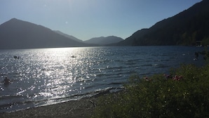 Un lac paisible, avec des montagnes en arrière-plan et un ciel dégagé.