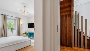 Een moderne slaapkamer met een bed, een televisie en een houten trap.