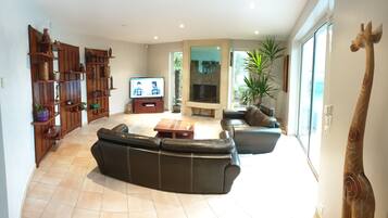 TV connectée, cheminée, table de tennis de table, livres