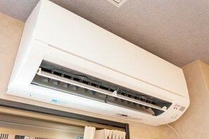 Un equipo de aire acondicionado instalado en la pared, con un panel de control visible y una rejilla de ventilación.