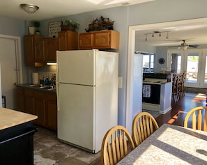 Enjoy meals in the kitchen with a dining area leading to a dining room offering a view of the outdoors.