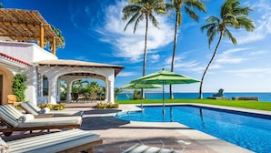 A pool area with lounge chairs, a covered seating area, and a view of the ocean. - 4 BR Cas Lita Includes A/C, WiFi, Private Pool and Much More! (Palmilla)