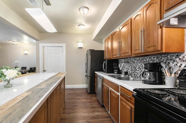 A modern kitchen with wooden cabinets, stainless steel appliances, and a tiled backsplash.