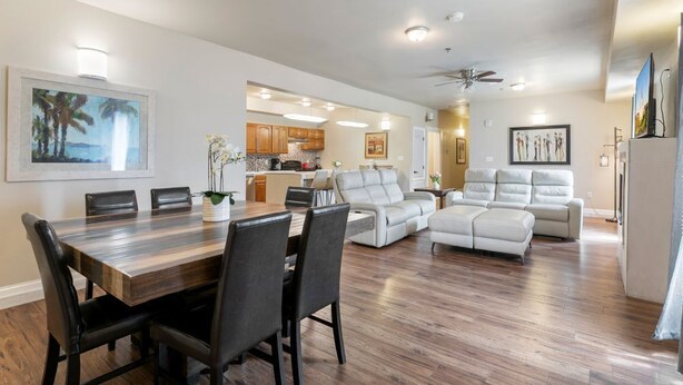 A spacious living room with a dining area, a kitchen in the background, and a ceiling fan. - 20% OFF Monthly | 10% OFF Weekly-Spacious and Fully Furnished Condo Near St. Charles (New Orleans)