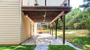 A covered outdoor patio with a stone pathway leading to a building entrance.