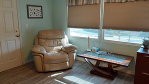 A room with a leather recliner, a wooden desk, and a window with blinds. - Clean spacious 2BR mobile home in great senior community in Largo Florida (Largo)