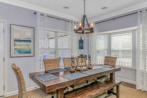 A dining room with a wooden table, wicker chairs, and a chandelier. - Best LOCATION in OCEAN LAKES!!!  (Myrtle Beach)
