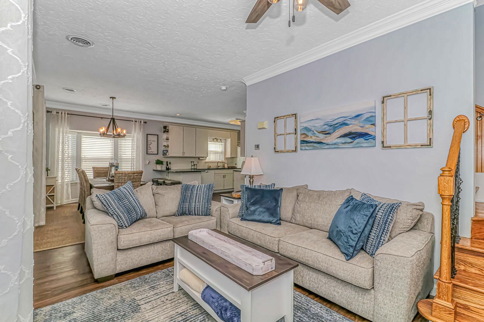 A living room with two sofas, a coffee table, and a staircase.