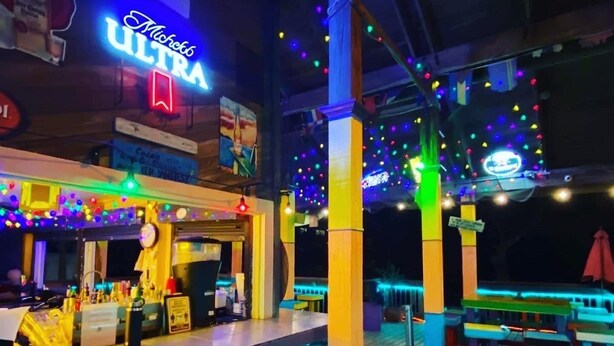 An outdoor bar area with colorful lighting, a neon sign, and wooden pillars. - Updated villa minutes walk to the beach. Seasonal heated outdoor pool (Hilton Head Island)